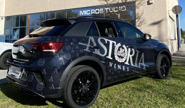 SUV scuro decorato lateralmente con logo di grandi dimensioni e motivi grafici