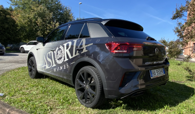 SUV grigio visto posteriormente con adesivi e logo applicati sulla fiancata