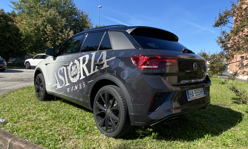 SUV grigio visto posteriormente con adesivi e logo applicati sulla fiancata