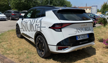 SUV bianco visto posteriormente con adesivi laterali e logo sul portellone