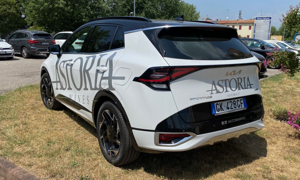 SUV bianco visto posteriormente con adesivi laterali e logo sul portellone