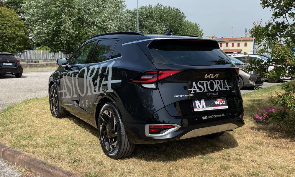 Vista posteriore di SUV nero decorato con logo e scritte aziendali