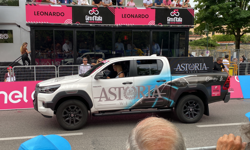 Pickup bianco decorato con grafica aziendale esposto durante una manifestazione