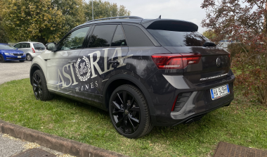 Vista posteriore laterale di SUV decorato con scritte pubblicitarie e logo